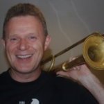 Åge Østrem poserer med trompeten over venstre skulder.