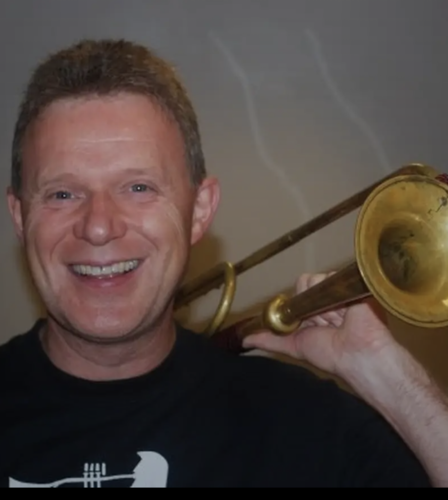 Åge Østrem poserer med trompeten over venstre skulder.